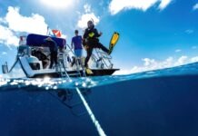 a group of people standing on top of a boat in the ocean