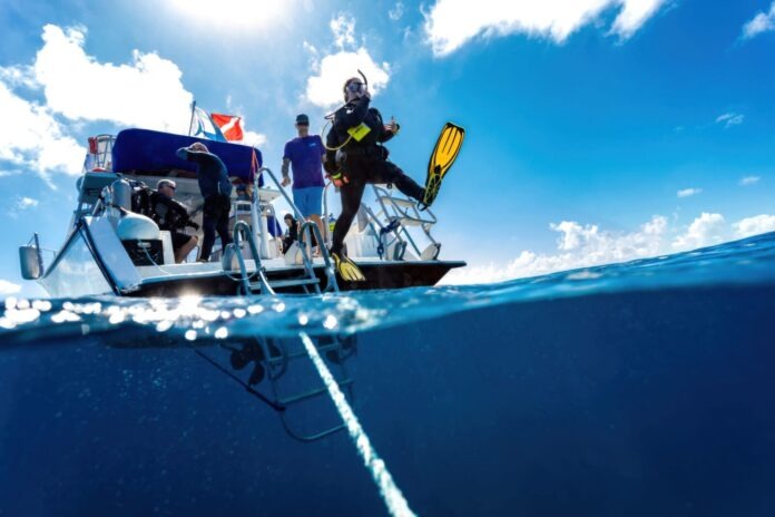 DestinationDive01 a group of people standing on top of a boat in the ocean