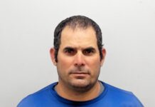 a mug shot of a man in a blue shirt