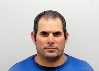 a mug shot of a man in a blue shirt