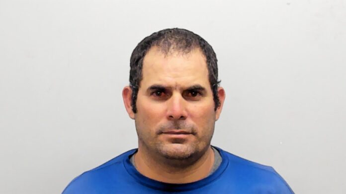 a mug shot of a man in a blue shirt