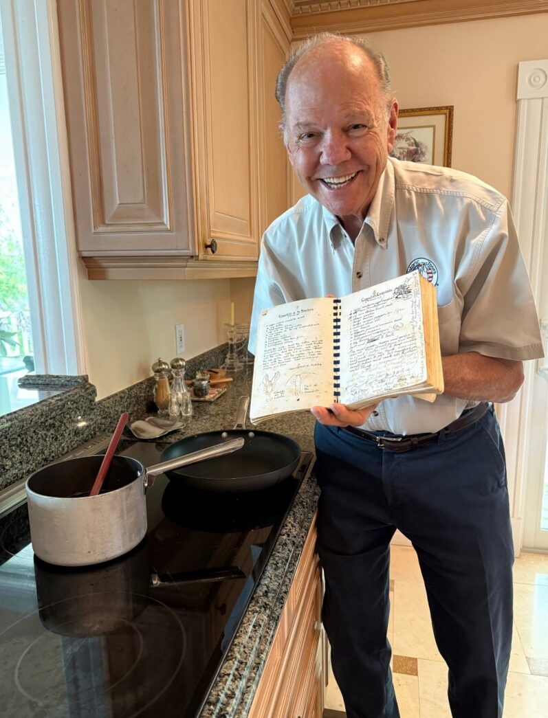 a man standing in a kitchen holding a book