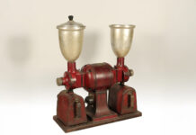 a red and silver machine with a silver cup on top of it