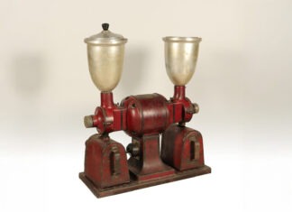 a red and silver machine with a silver cup on top of it