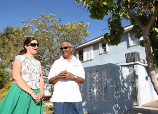 a man and a woman standing in front of a house
