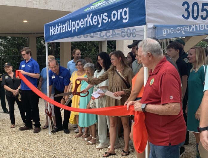 Habitat homes 2 Large a group of people standing around a ribbon cutting