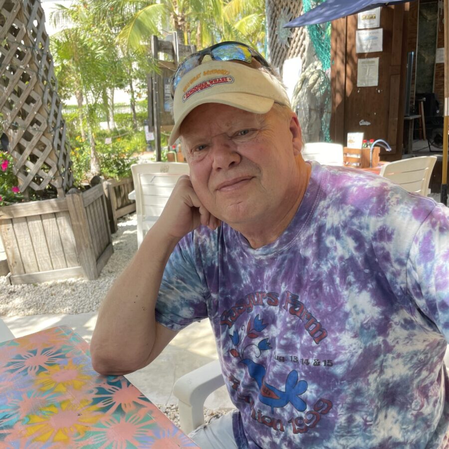 an older man sitting at a table with a plate of food