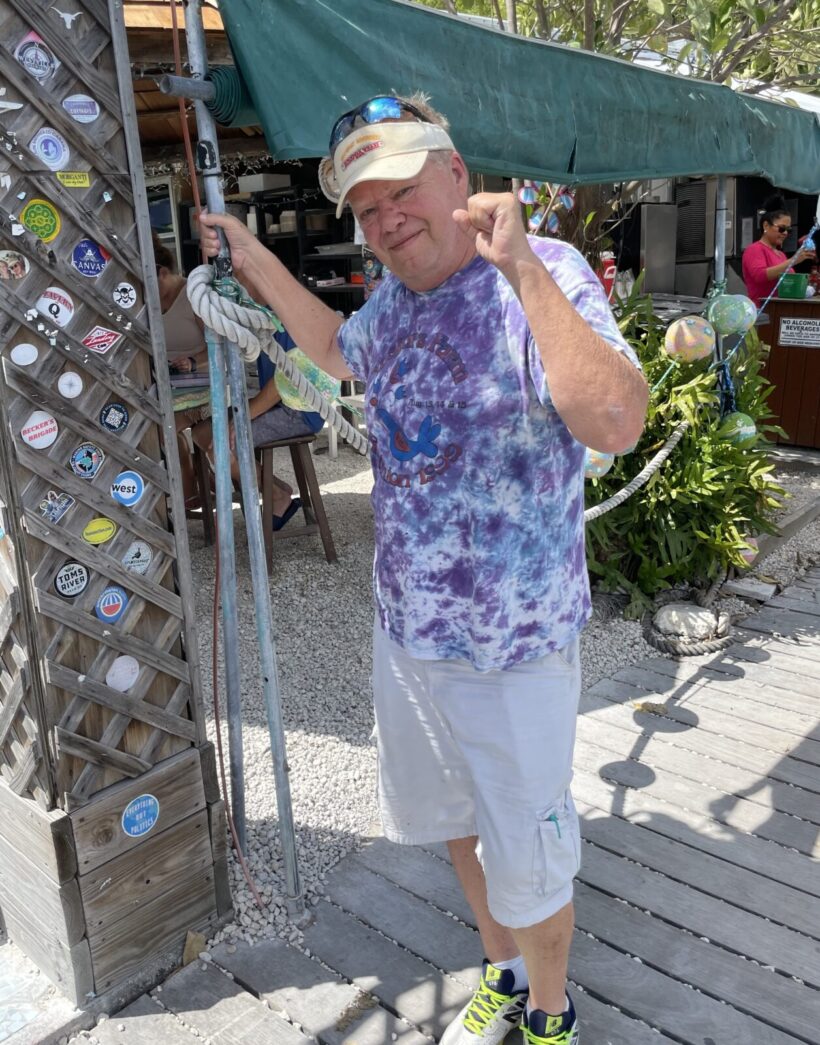 a man in a tie dye shirt is holding a pair of skis