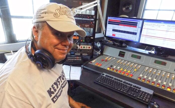 a man sitting in front of a mixing desk