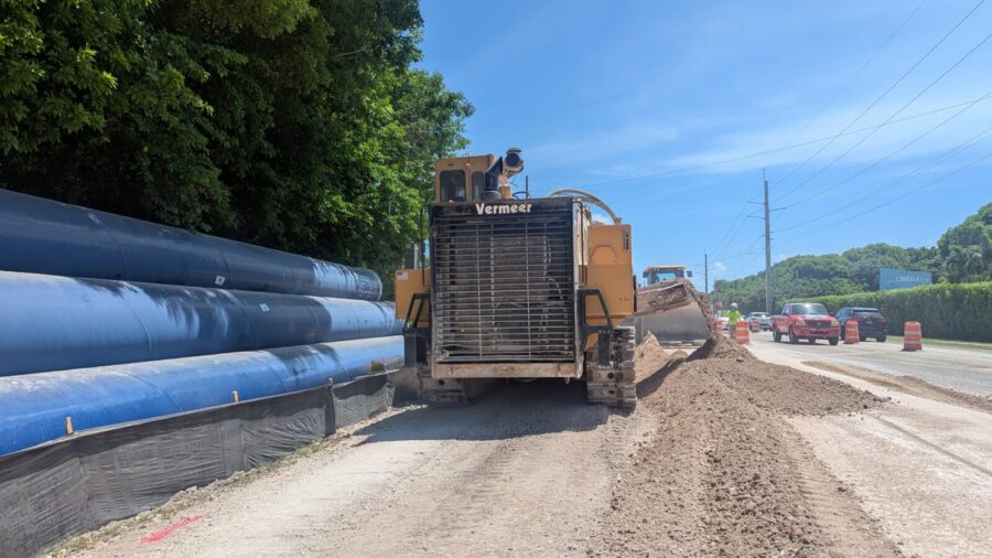 a large truck driving down a road next to a forest