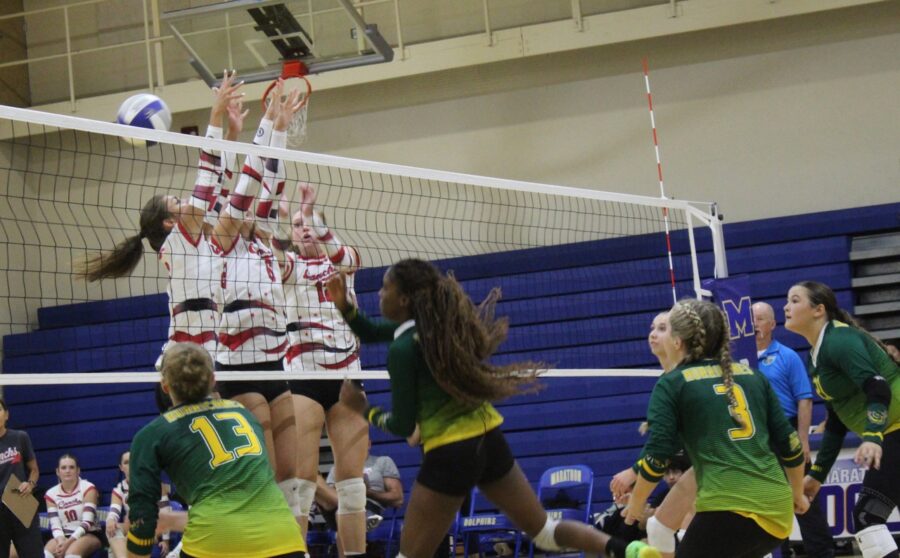 a group of young women playing a game of volleyball