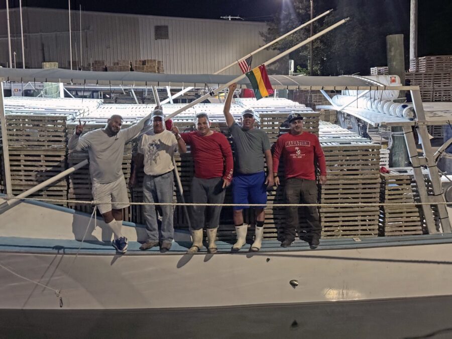 a group of men standing on top of a boat
