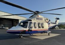 a helicopter parked in front of a hangar