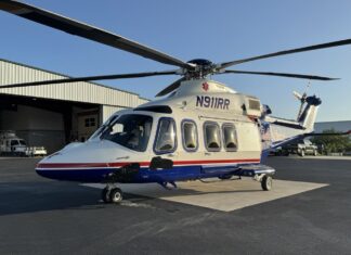 a helicopter parked in front of a hangar