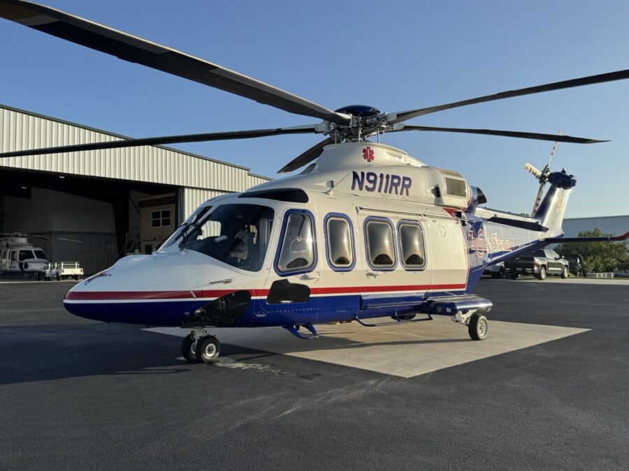 a helicopter parked in front of a hangar