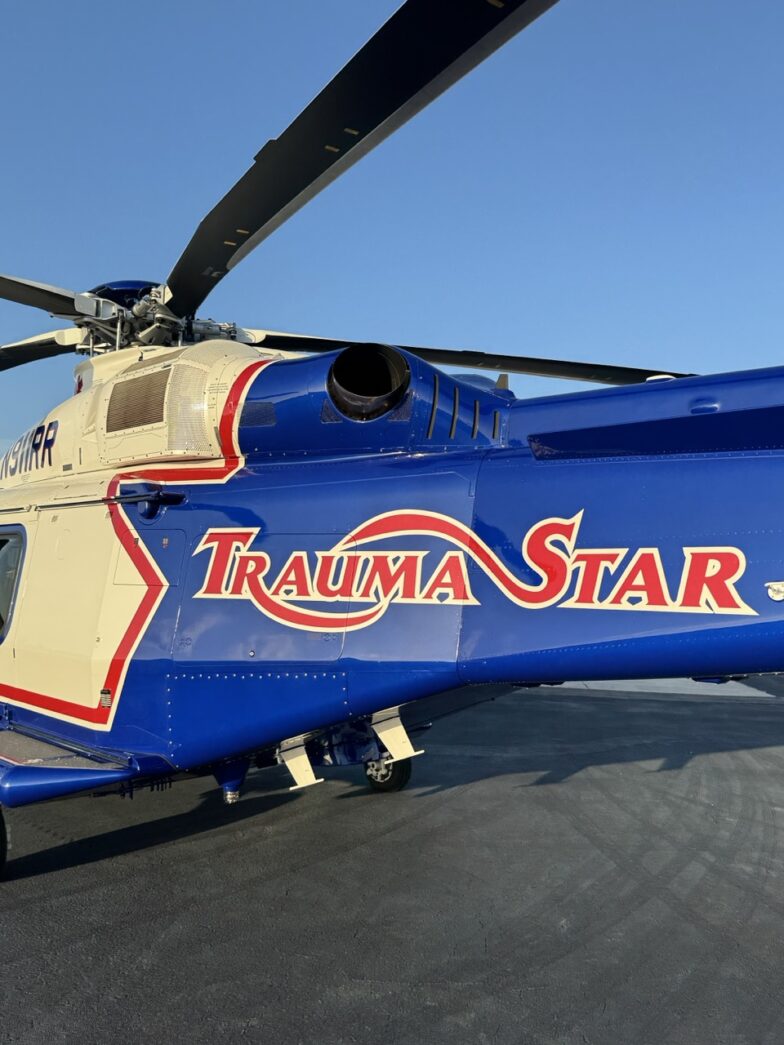 a blue and white helicopter sitting on top of a tarmac