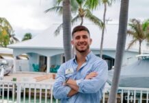 a man standing in front of a palm tree