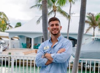 a man standing in front of a palm tree