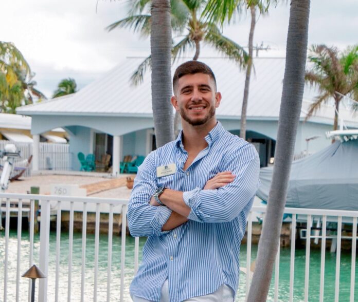 a man standing in front of a palm tree