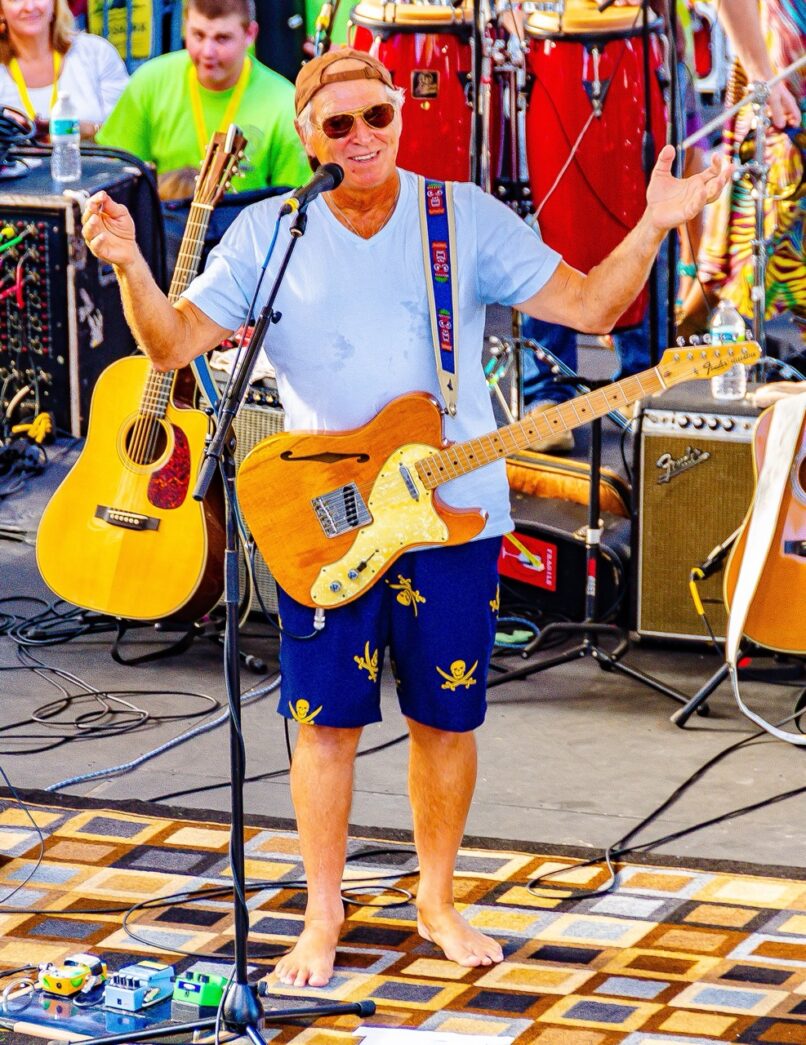 a man standing on top of a stage holding a guitar
