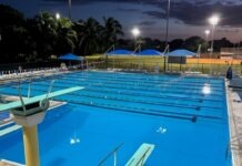 an empty swimming pool at night with lights on