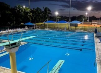 an empty swimming pool at night with lights on