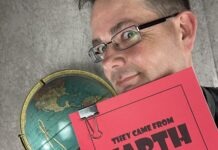a man holding a red book over his face