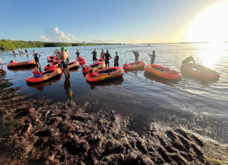 a group of people standing on top of a body of water