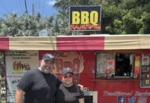 a man and a woman standing in front of a food truck