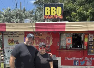 a man and a woman standing in front of a food truck