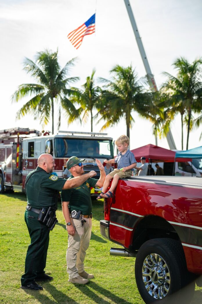 a group of men standing around a red truck