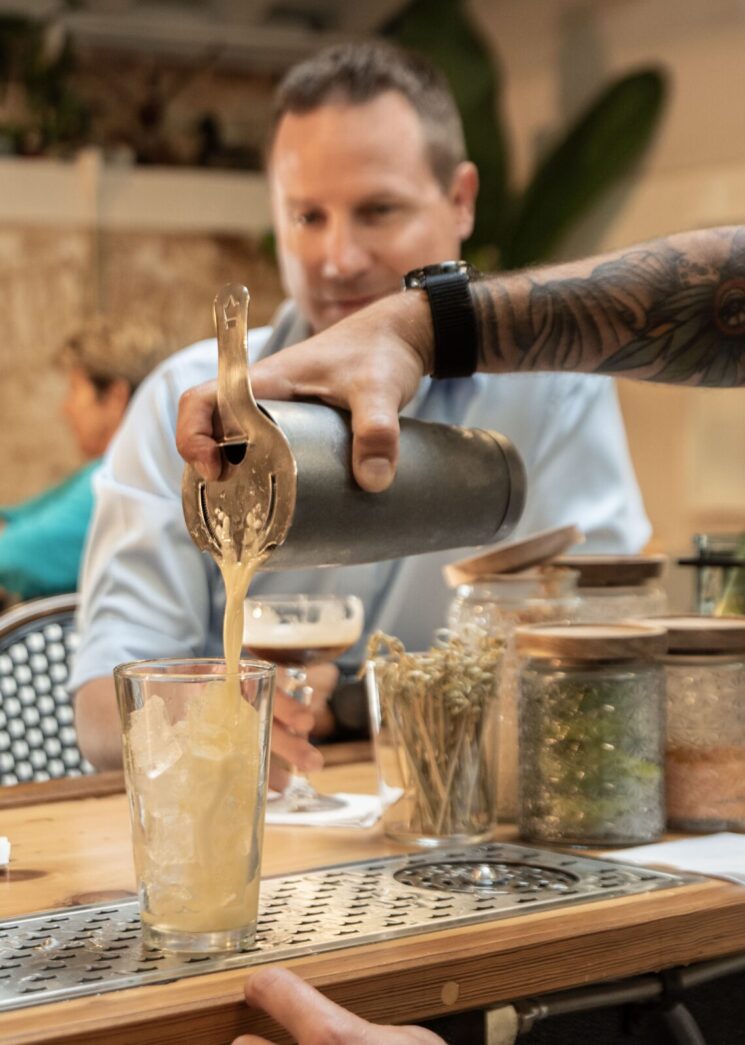 a man pouring a drink into a glass