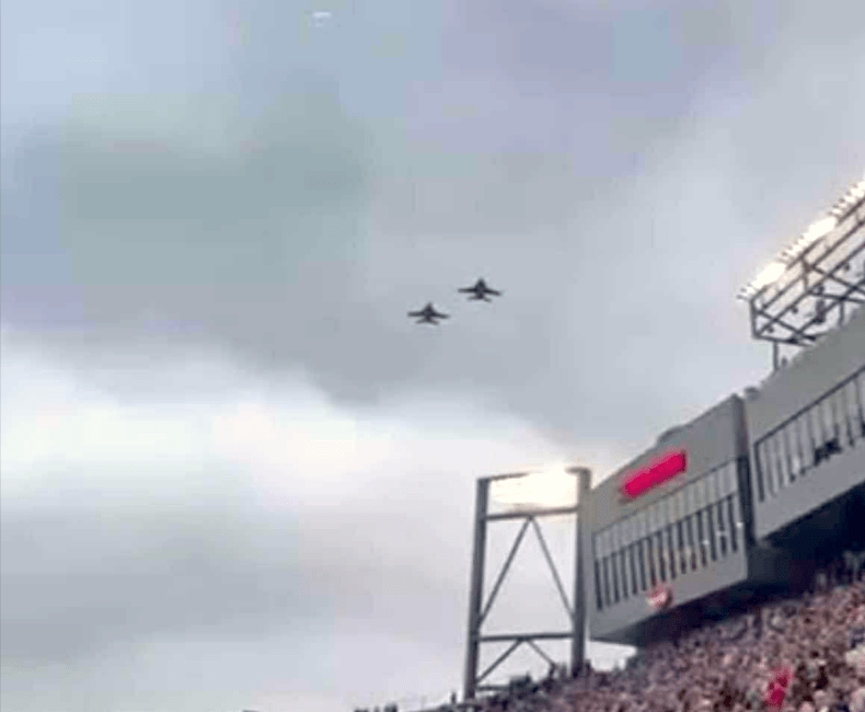 a group of airplanes flying over a crowd of people