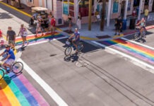 a group of people riding bikes down a street
