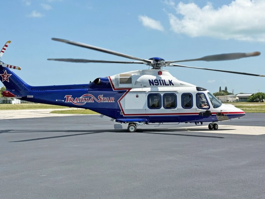 a blue and white helicopter sitting on top of an airport tarmac