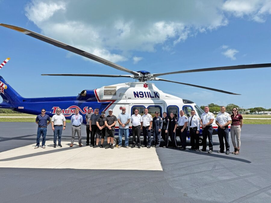 a group of people standing in front of a helicopter