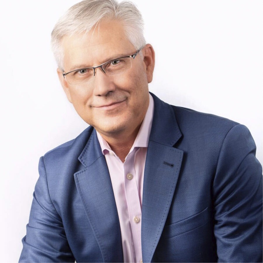 a man in a blue suit and pink shirt