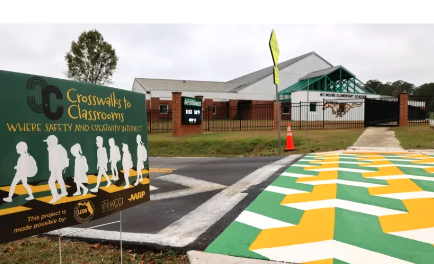 a green and yellow sign sitting on the side of a road