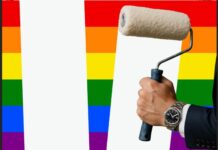a hand holding a paint roller with a rainbow background