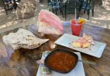 a wooden table topped with plates of food
