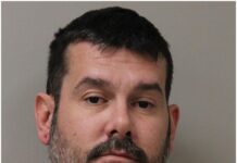 a mug shot of a man in an orange shirt