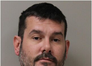 a mug shot of a man in an orange shirt