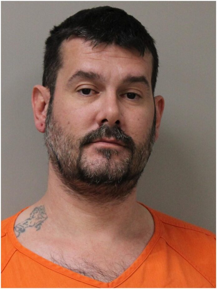 a mug shot of a man in an orange shirt