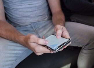 a man sitting on a couch using a cell phone