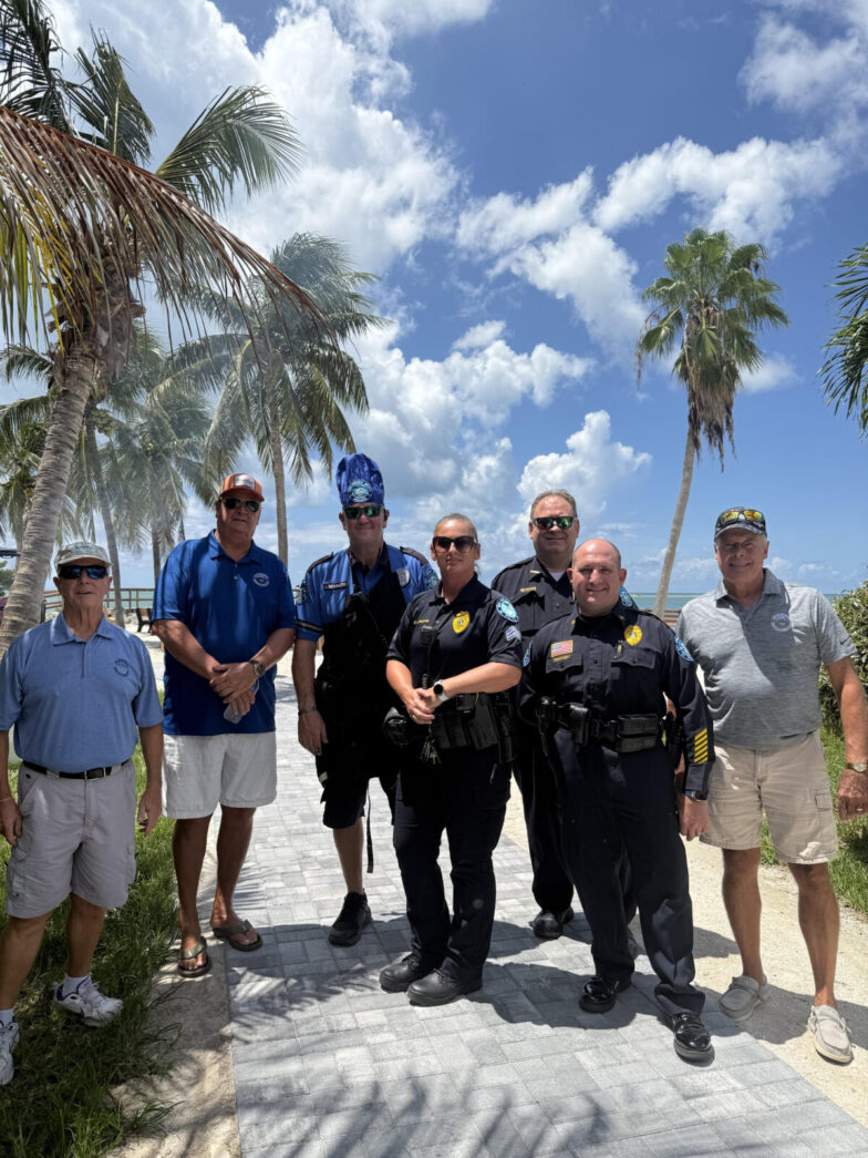 a group of men standing next to each other near a palm tree