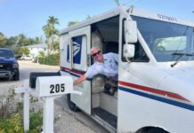 a man leaning out of a mail truck