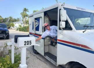 a man leaning out of a mail truck