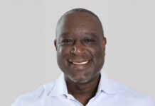 a man in a blue shirt smiles at the camera