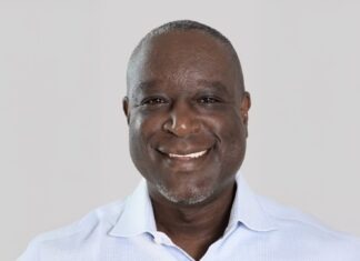 a man in a blue shirt smiles at the camera