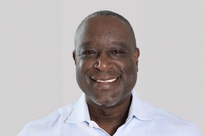 a man in a blue shirt smiles at the camera